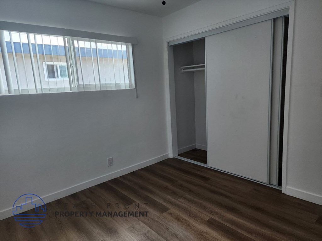 an empty bedroom with a closet and a window