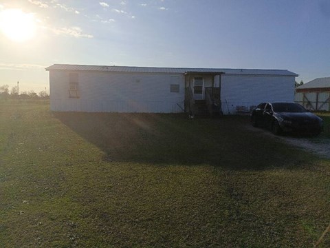 A white building with a car parked in front of it.