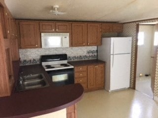 A kitchen with brown cabinets and a white refrigerator.
