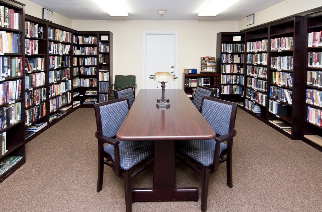 a library with a table and chairs and shelves of books