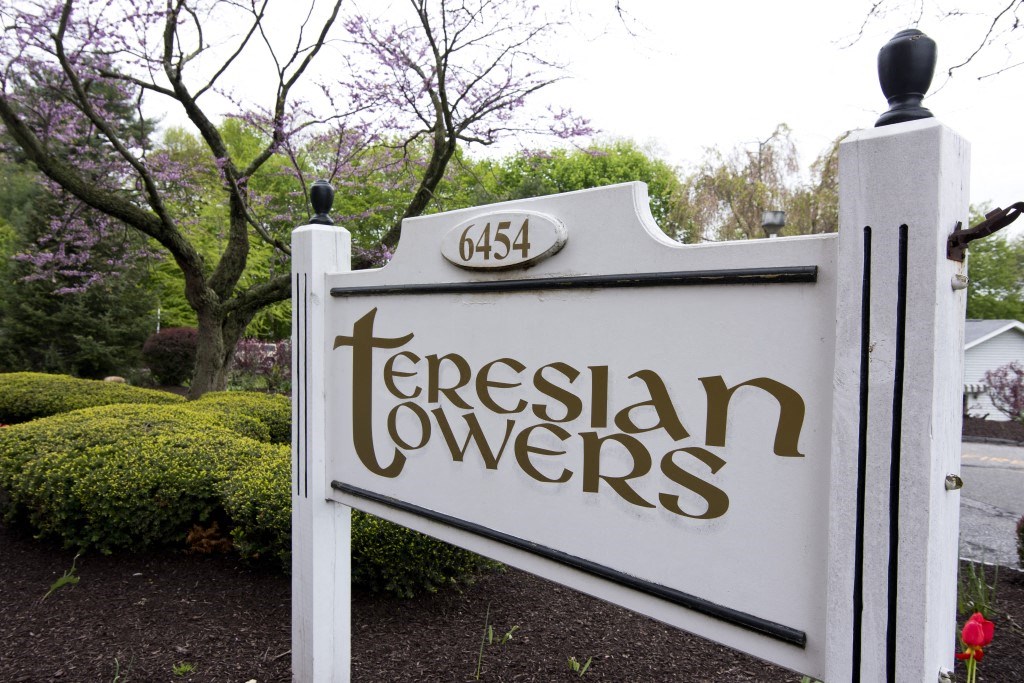 a sign that reads terrisan towers in front of a garden