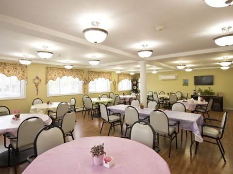 a dining room with tables and chairs in a room with yellow walls
