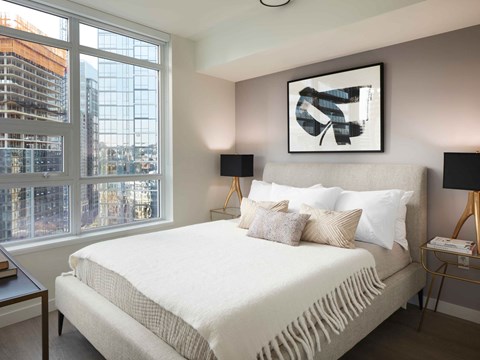 A bedroom with a large bed and a large window overlooking a construction site.
