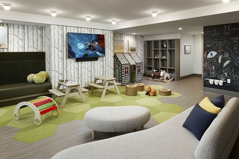A living room with a grey sofa and a painting on the wall.