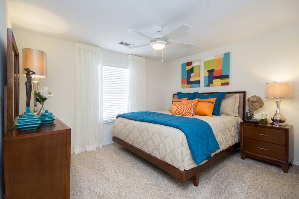 a bedroom with a bed and a ceiling fan