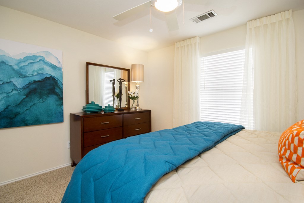a bedroom with a large bed and a ceiling fan