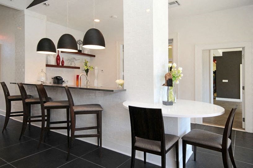 a kitchen with a counter and chairs and a table