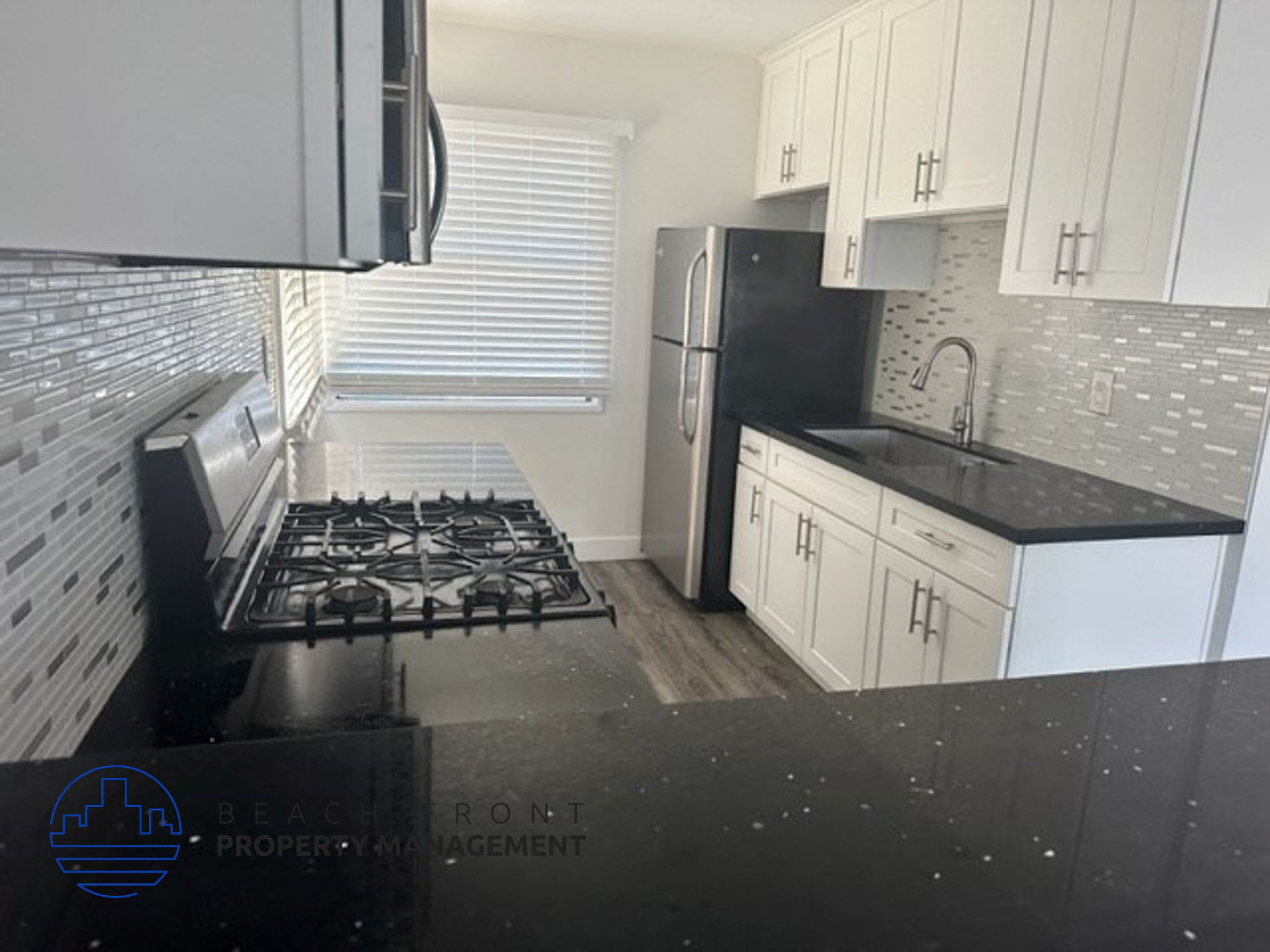 a black and white kitchen with a stove and a refrigerator