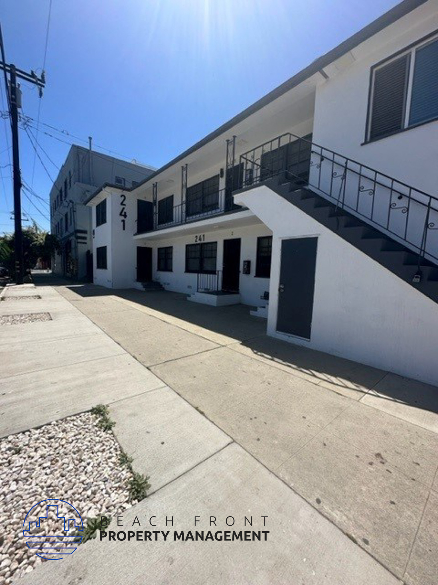 a white building with a sidewalk in front of it