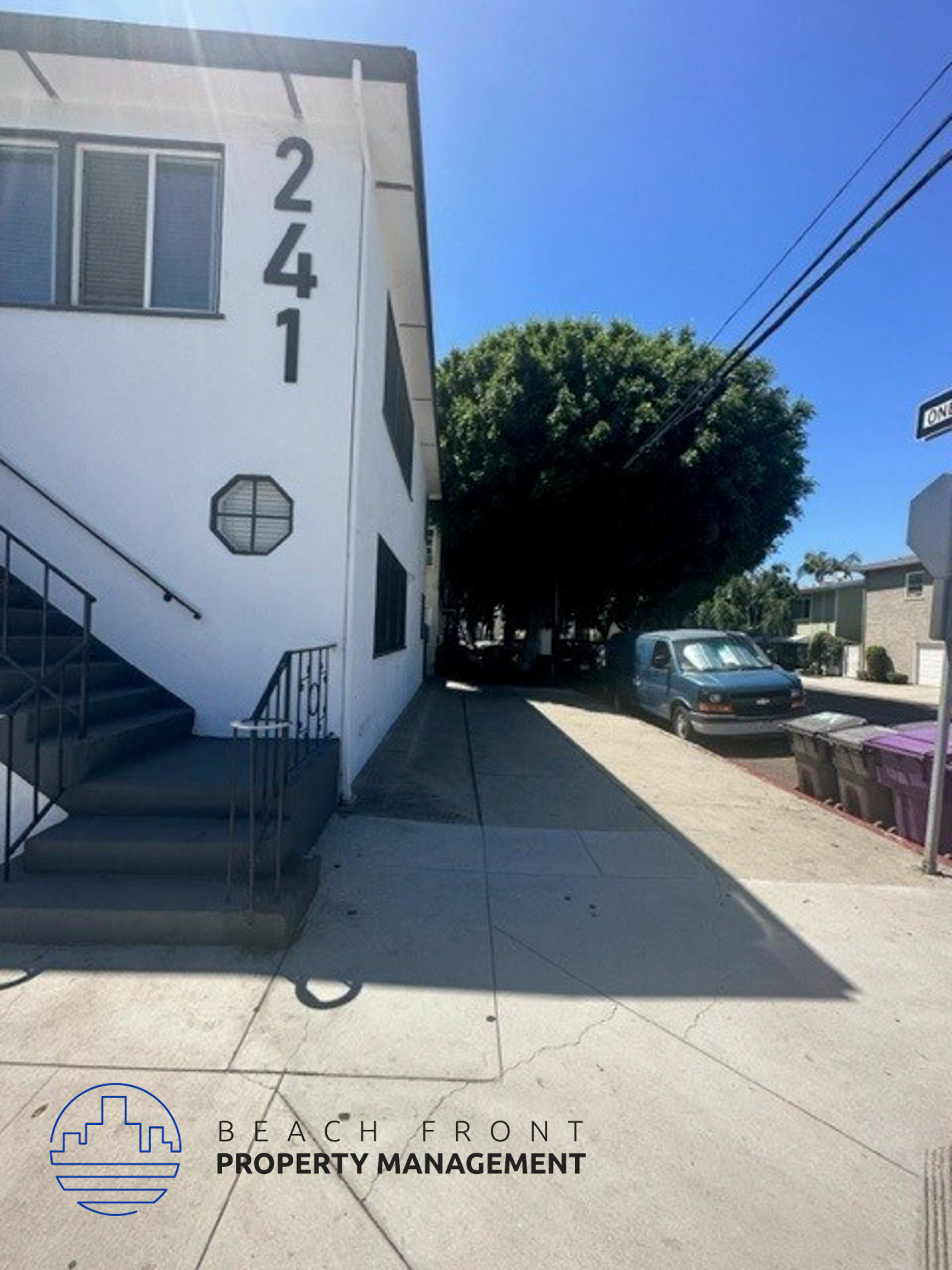 the side of a building with stairs and a tree