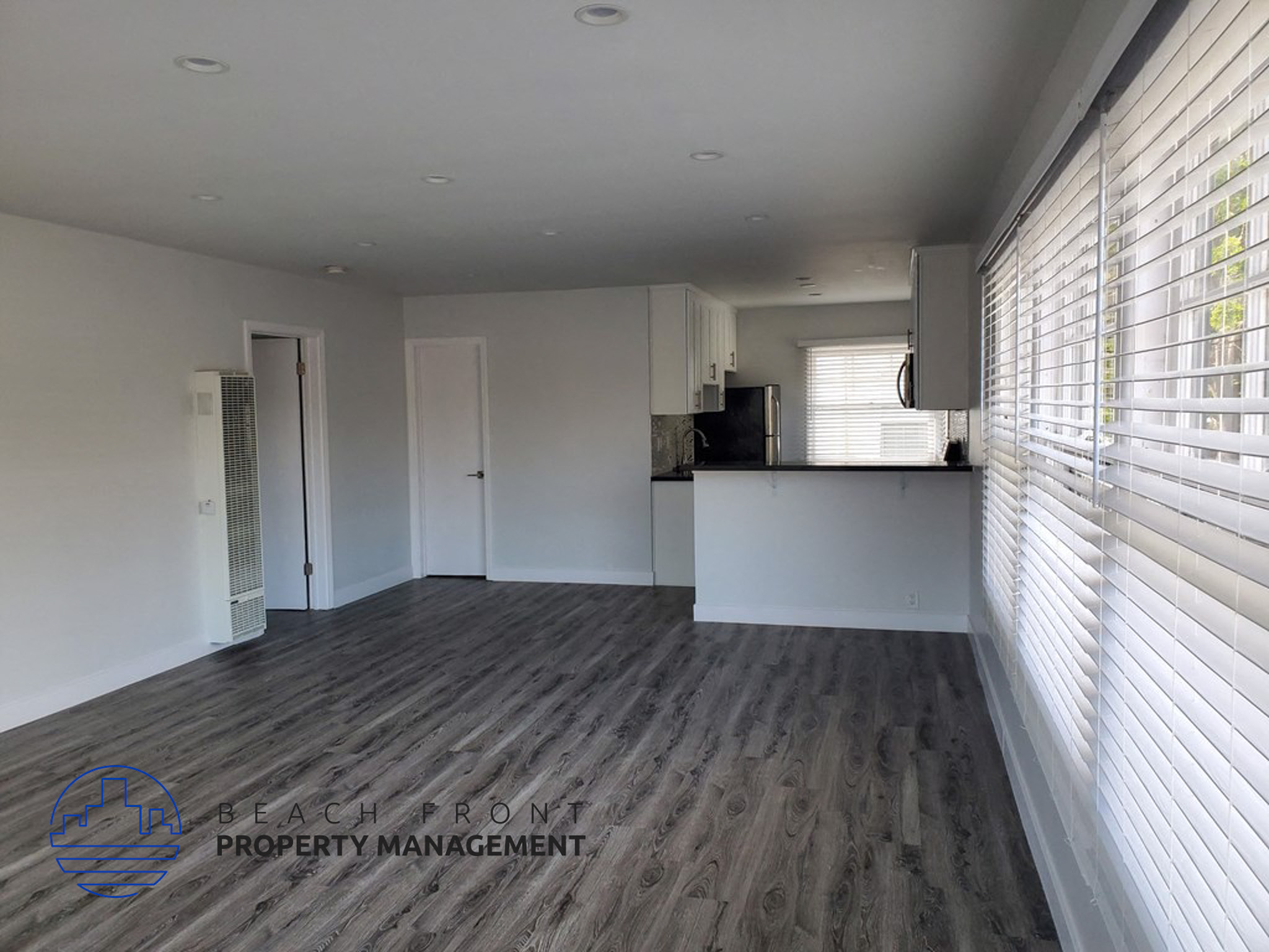 an empty living room with white walls and wood flooring