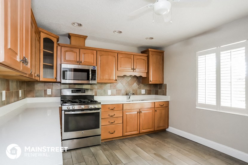a kitchen with wooden cabinets and stainless steel appliances
