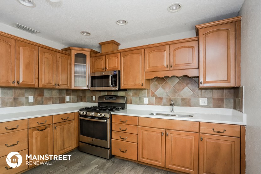 a kitchen with wooden cabinets and a stove and a sink