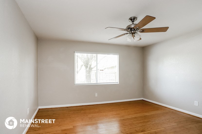a bedroom with a ceiling fan and wood floors