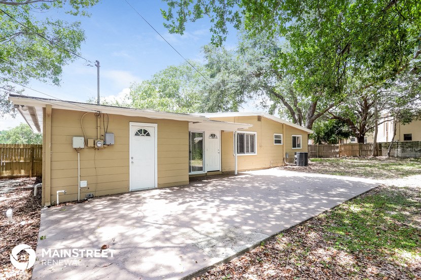 a yellow house with a driveway and a white door