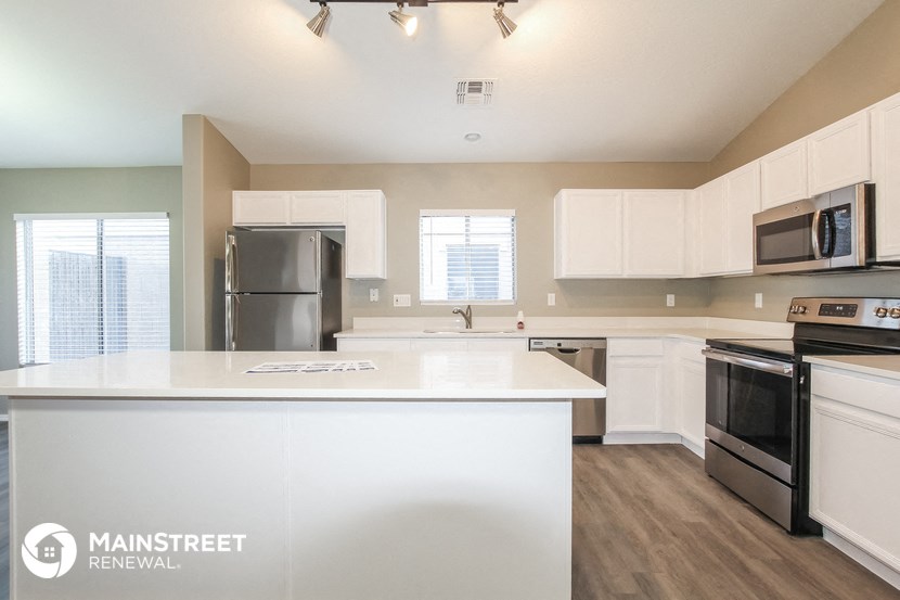 a kitchen with white counter tops and stainless steel appliances