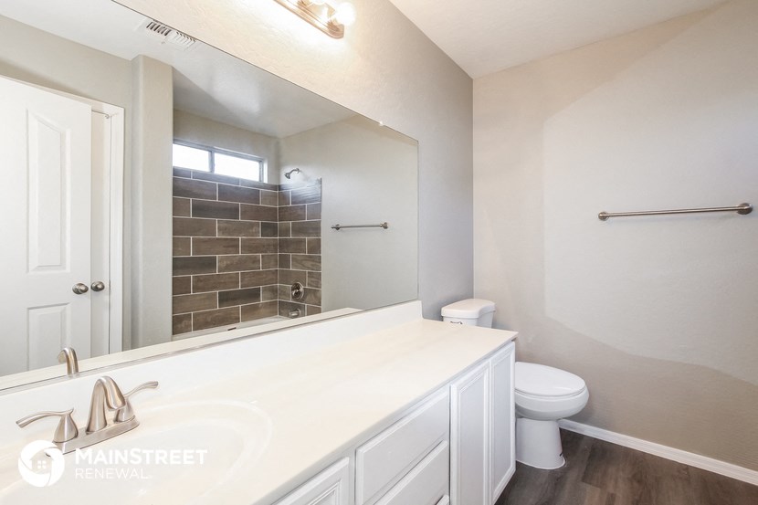 a bathroom with a large mirror and a sink and a toilet