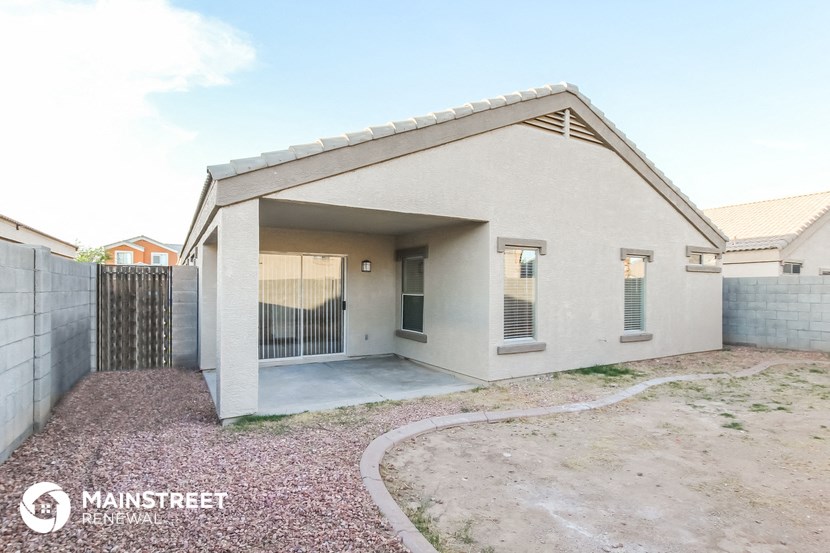 a small house with a driveway and a gate