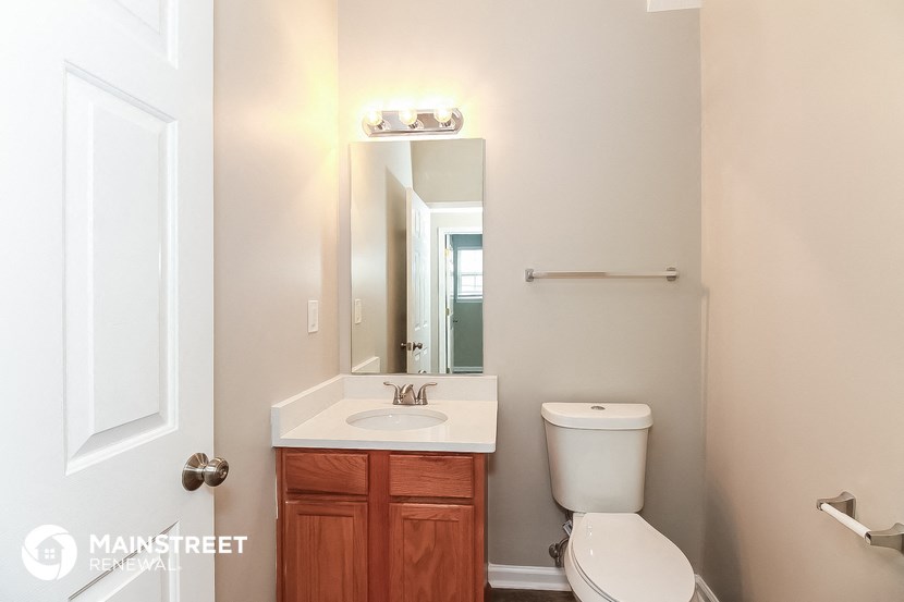 a bathroom with a toilet and a sink and a mirror