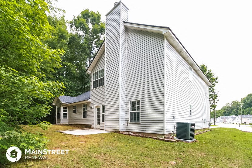 a home with a white house and a yard with trees