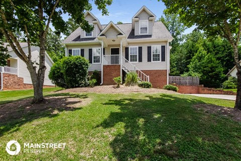 a house with a lawn and trees in front of it