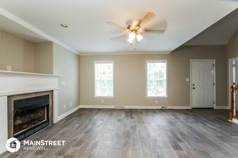 the living room with fireplace and ceiling fan