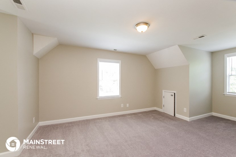the upstairs bedroom with carpet and a door to the closet