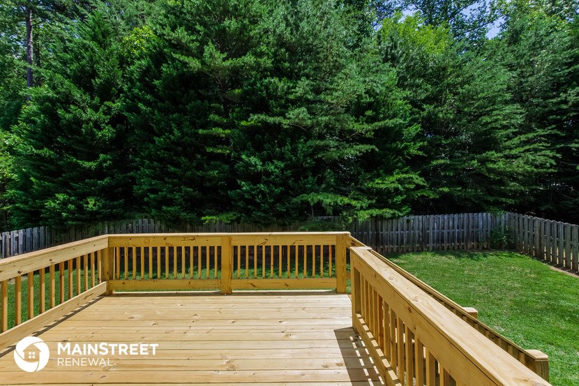 a wooden deck in the backyard of a home