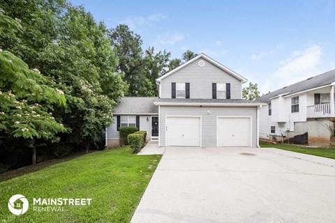 a white house with a driveway and a white garage door