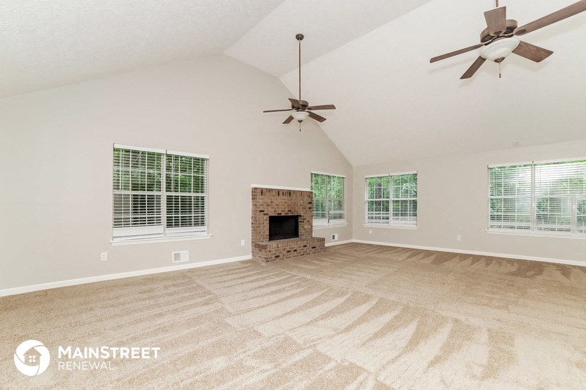 the living room is spacious and clean with a fireplace