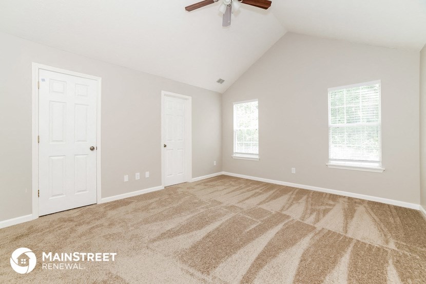 the master bedroom is spacious and clean with a ceiling fan