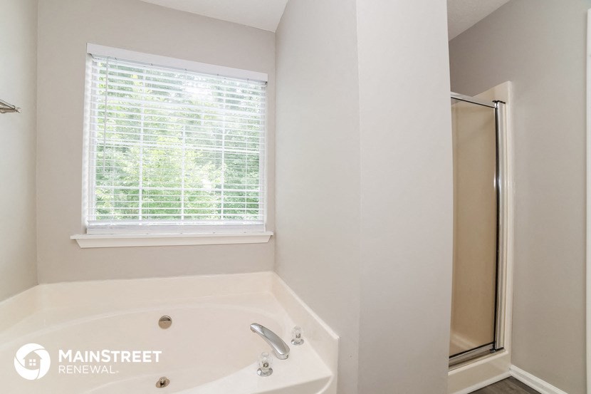 a bathroom with a tub and a shower and a window