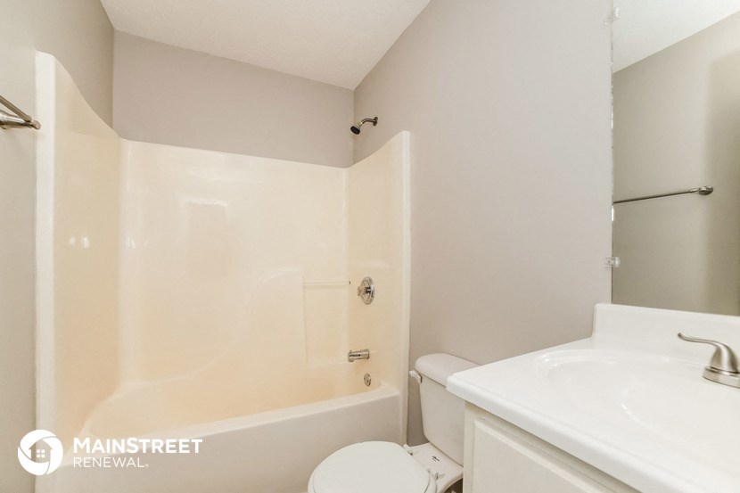 a bathroom with a toilet and a sink and a shower