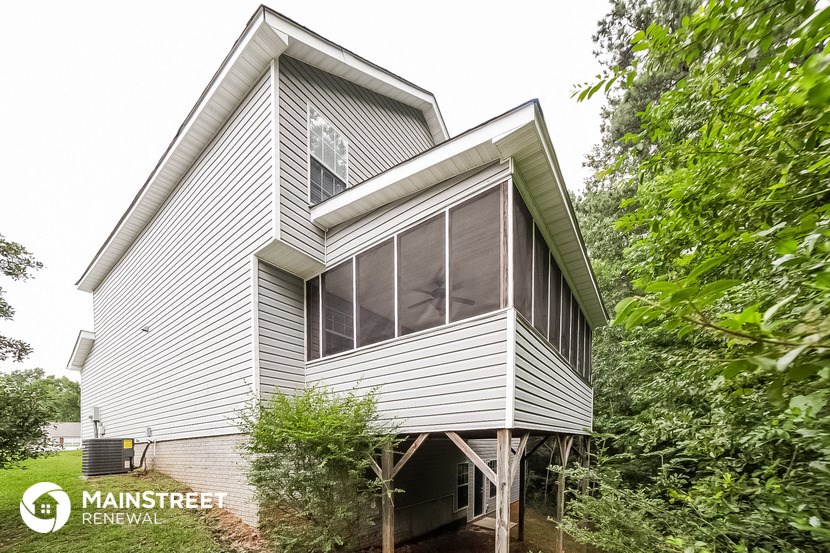 the exterior of a white house with trees