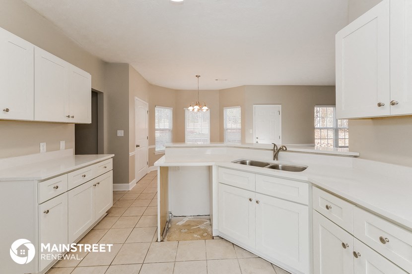 a large kitchen with white cabinets and a white counter top