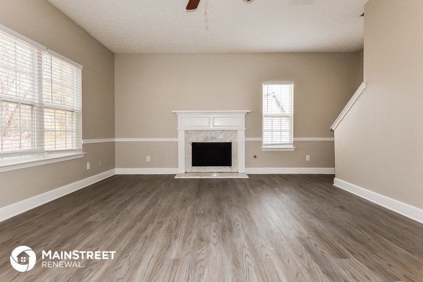 the living room of a new home with wood flooring and a fireplace