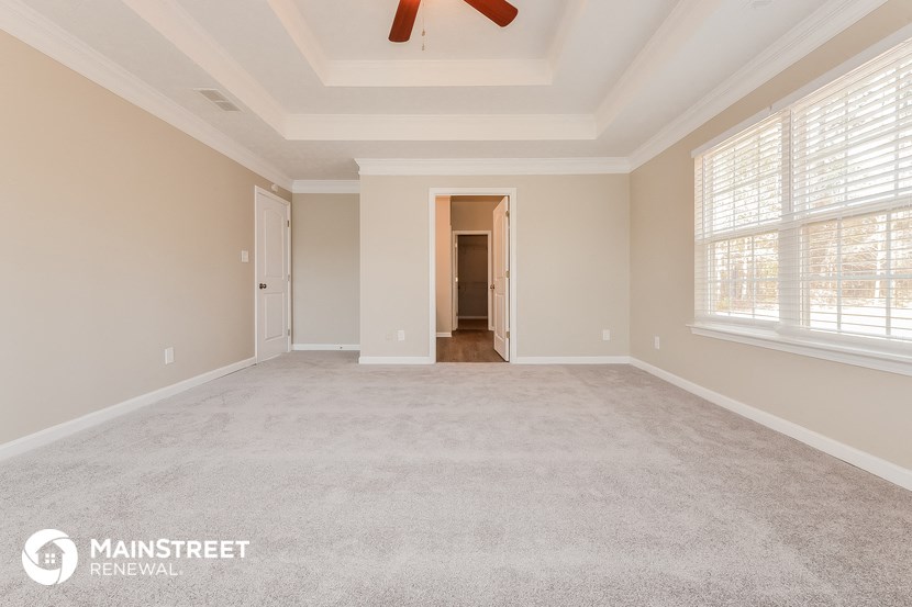 the master bedroom  carpeted room with ceiling fan