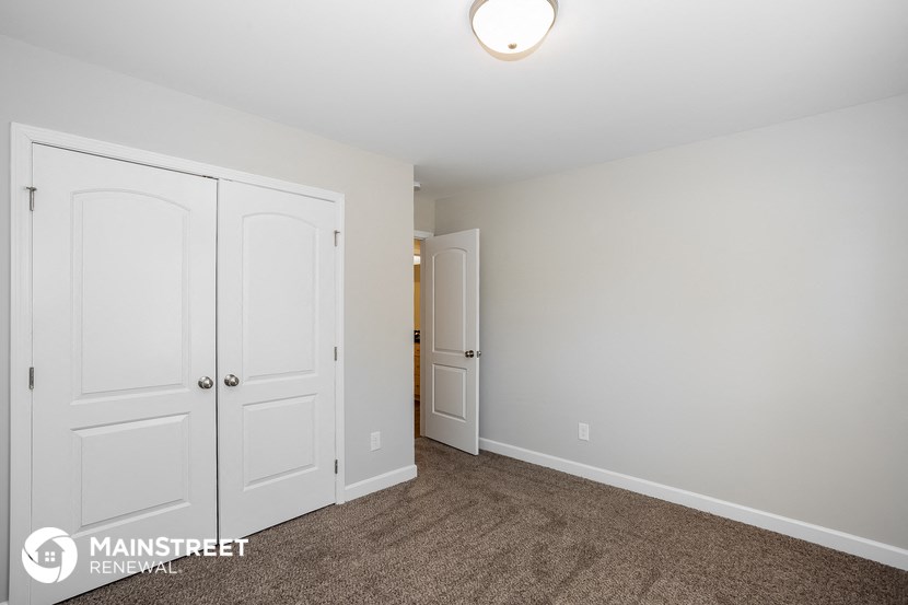 a bedroom with two closets and a door to a hallway