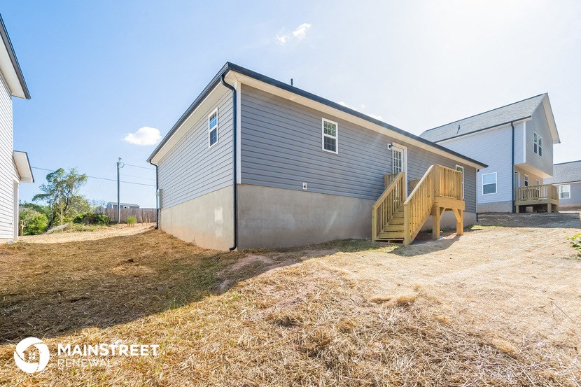 a small blue house with a backyard and stairs