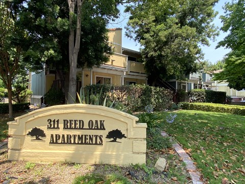 a sign for the 3rd real oak apartments is shown in front of a lawn