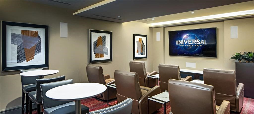a dining room with tables and chairs and a large picture on the wall