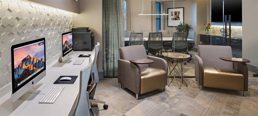 a conference room with computers and chairs and a table