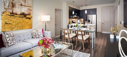 a living room with a couch and a table and a kitchen