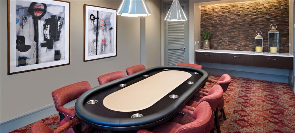 a poker table in a room with red chairs