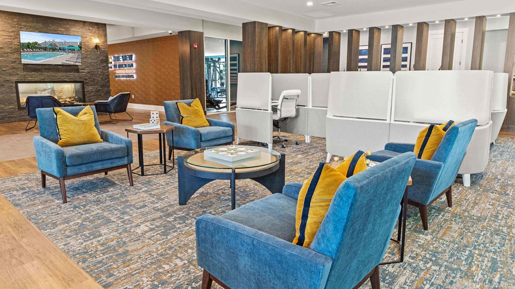 a lounge area with blue chairs and a fireplace