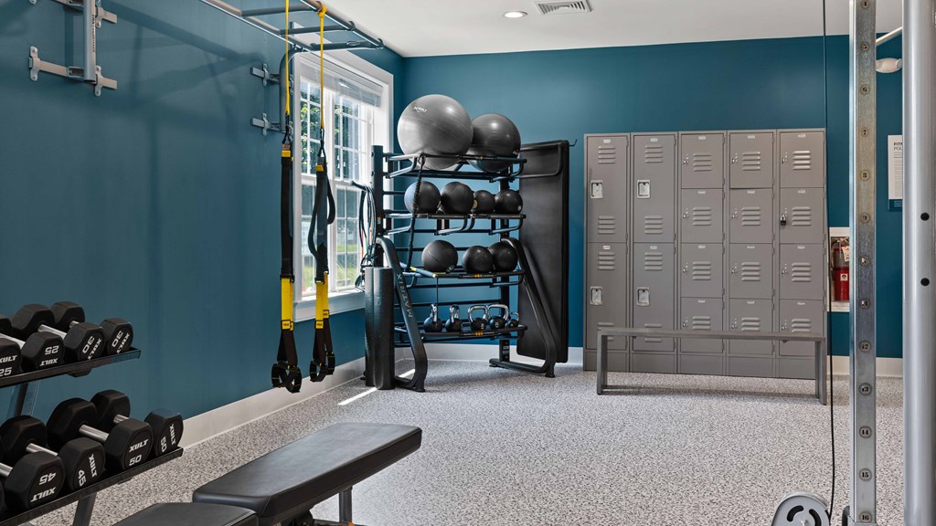 a gym with weights and lockers and a window