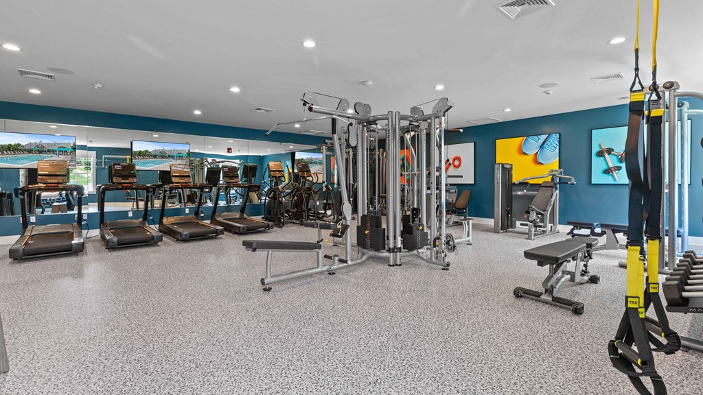 a gym with cardio equipment and weights in a building with blue walls