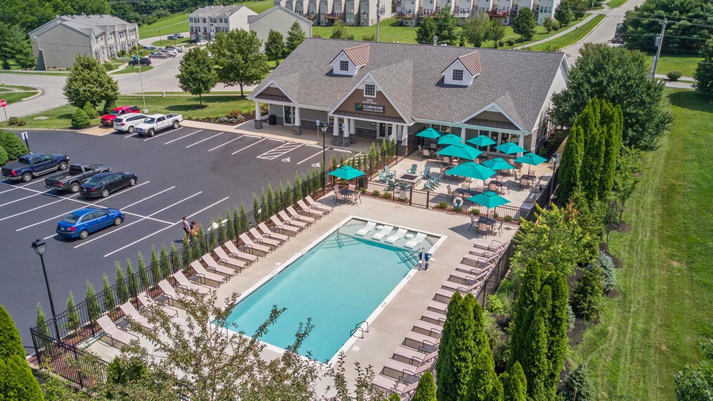 an aerial view of a swimming pool in front of a house