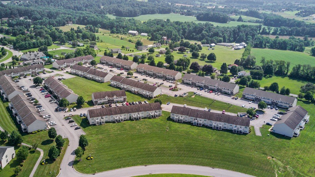 an aerial view of a neighborhood of buildings and a green field
