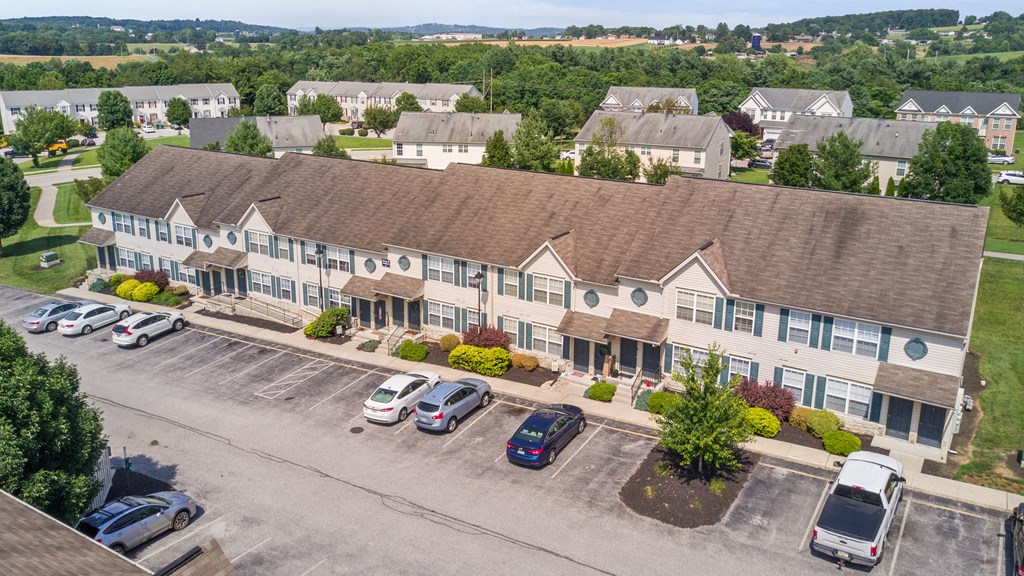 an aerial view of a building with cars parked in front of it